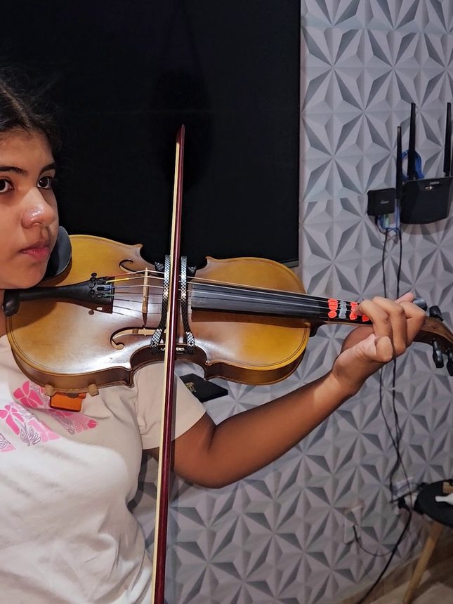 Aluna tocando violino, vista de perfil